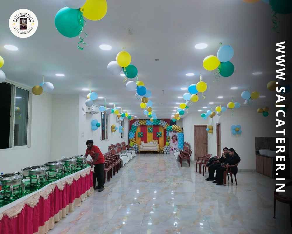 Clean birthday venue with catering staff decorating buffet counter