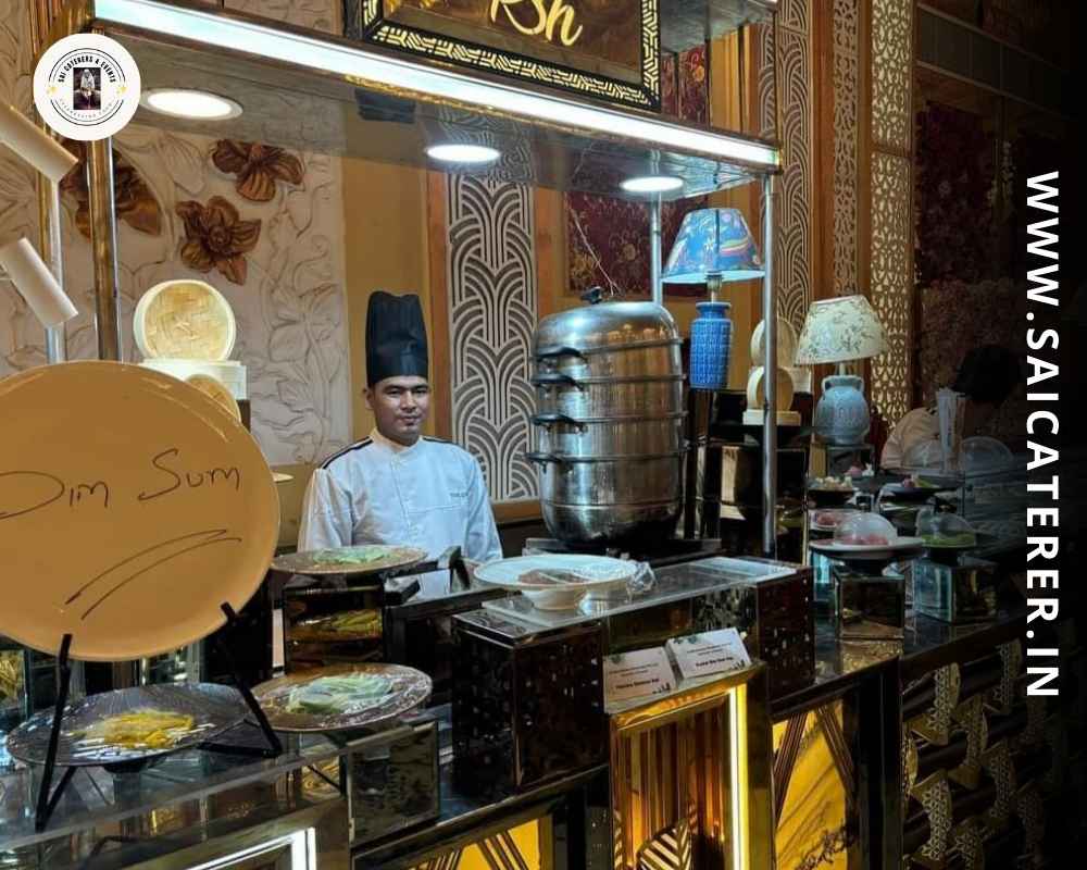 Chef in white uniform and black cap making momos at catering counter