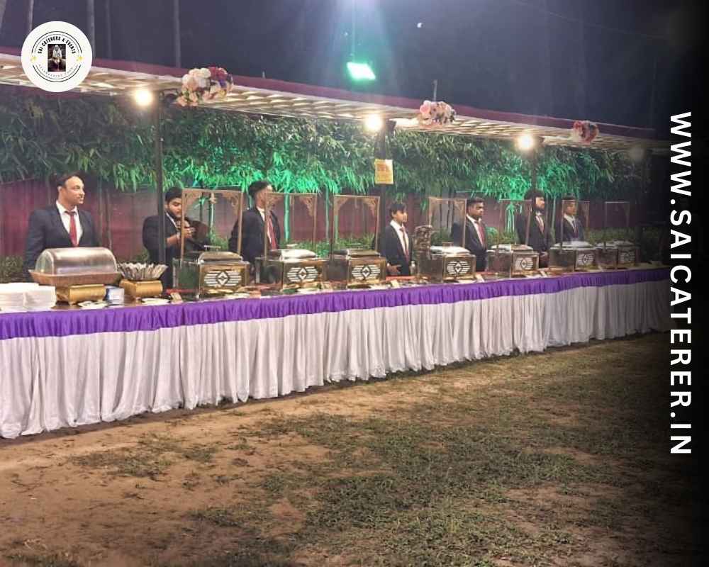 Outdoor catering buffet in garden with blazered staff and hygiene setup